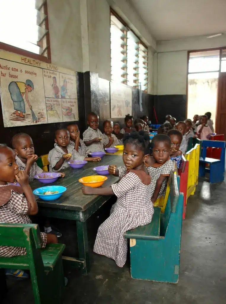 Photo of children eating a meal at school in an informal settlement