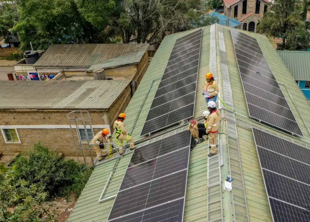 Photo of people inspecting solar panels on a roof